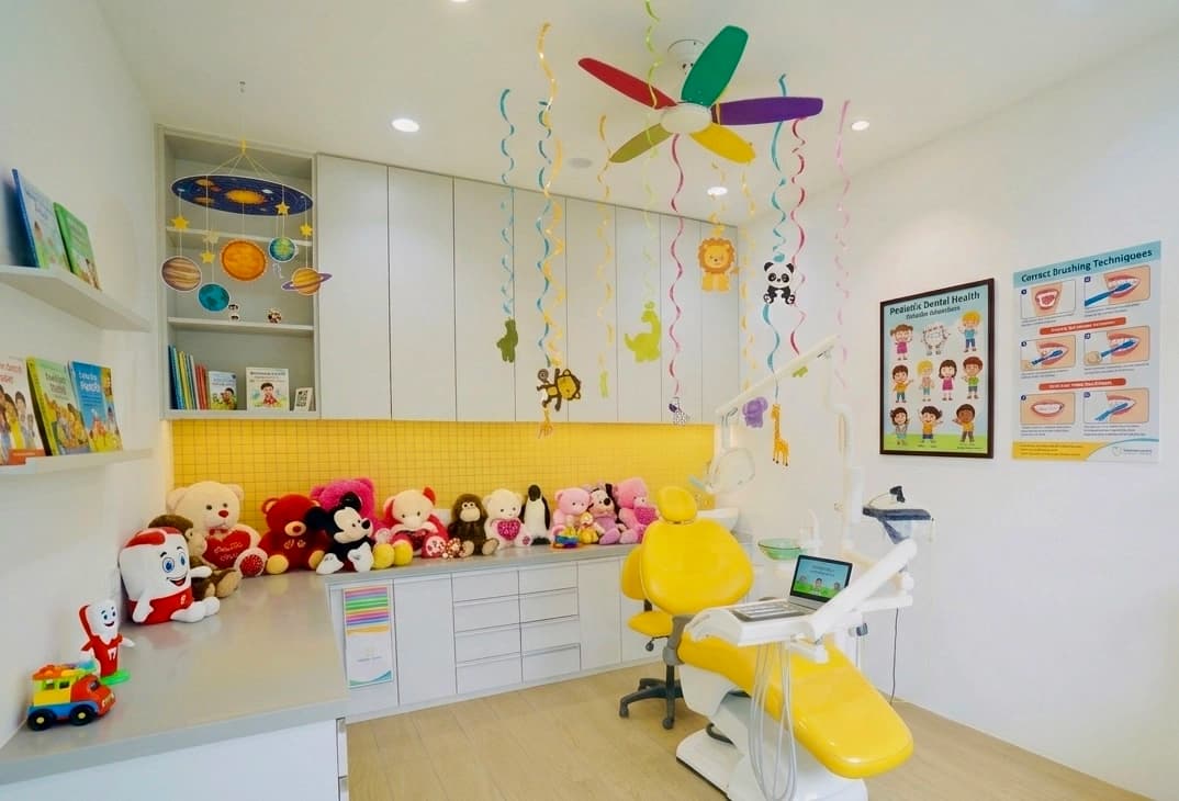 Child-friendly yellow dental room with toys at Bhai-Bhai Dental Clinic